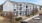 apartment buildings with cars in a parking lot