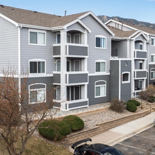 apartment buildings with cars in a parking lot